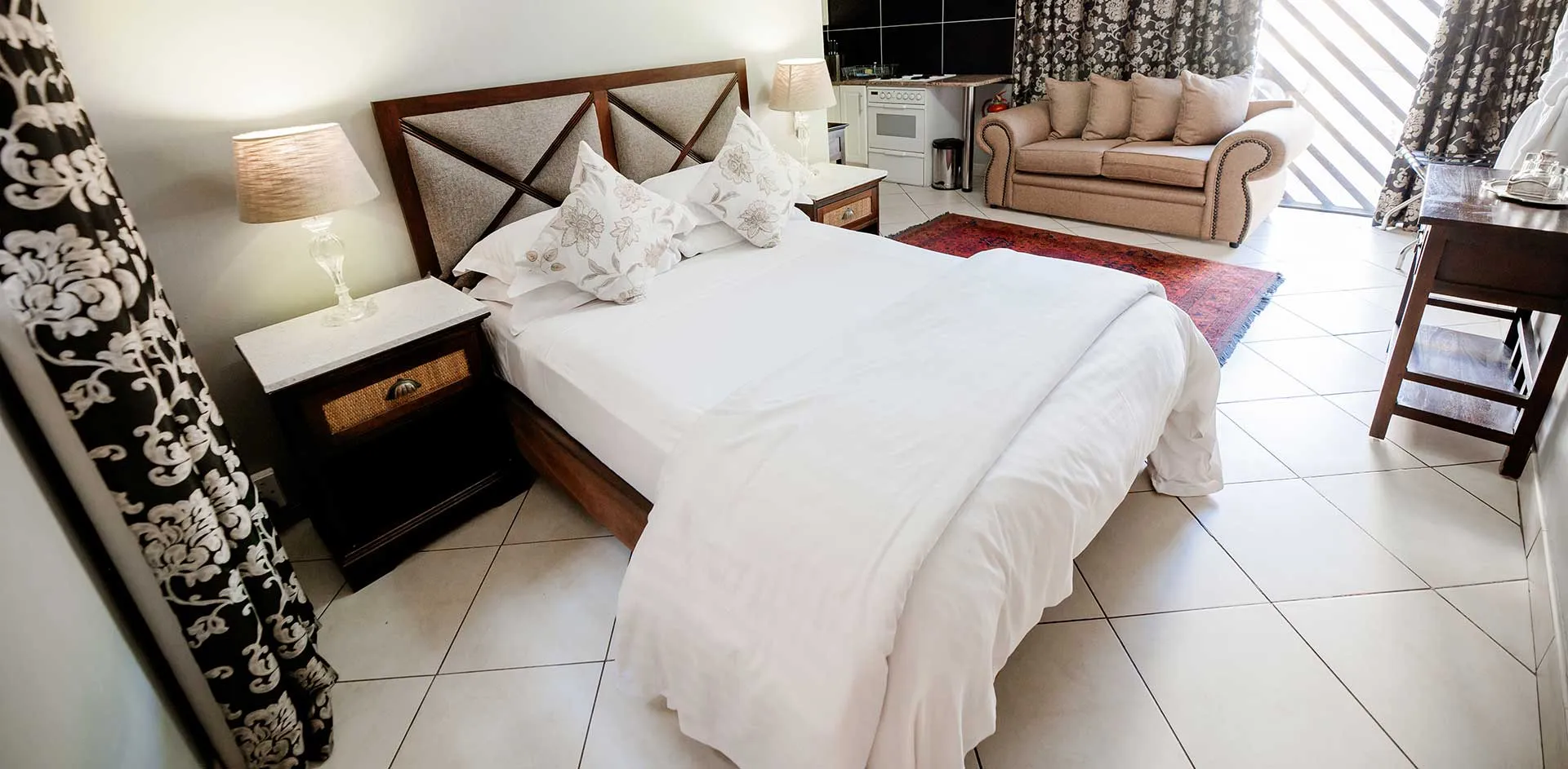 Bedroom with a large bed sofa and tiled floor