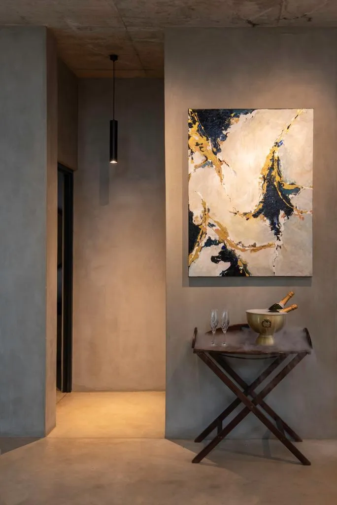 Modern hallway with abstract painting wine glasses and a decorative bowl on a table