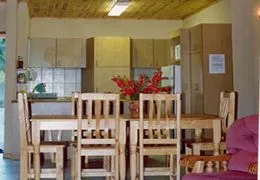 Wooden dining table with six chairs in a cozy kitchen with floral centerpiece