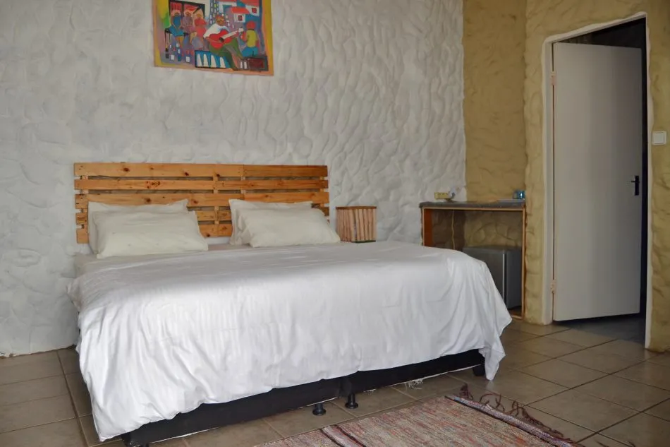 Bedroom with a bed textured wall and a door leading to another room