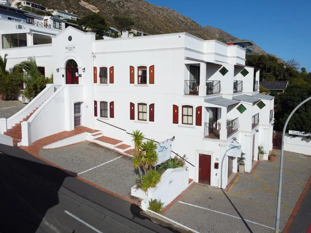 White building with red doors and windows courtyard and hillside background