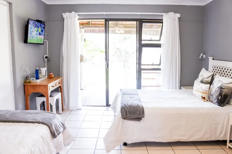 Bedroom with two beds TV and sliding glass doors to a patio
