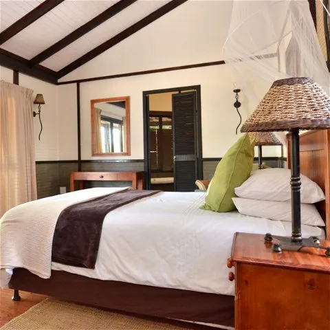 Cozy bedroom with a large bed wooden furniture and a mosquito net
