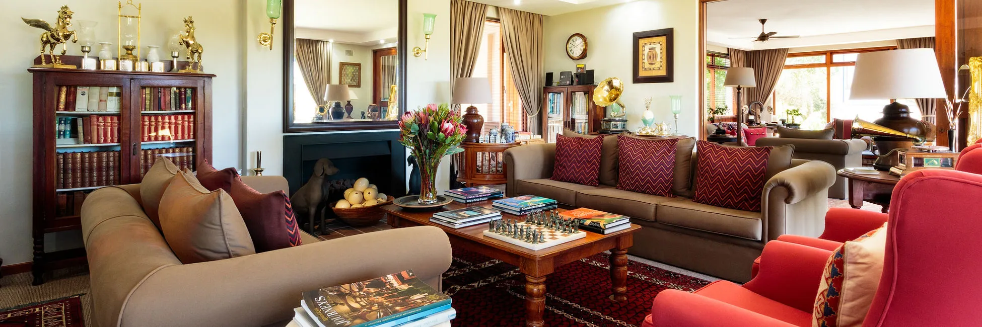 Cozy living room with sofas bookshelves fireplace and a chessboard on a table