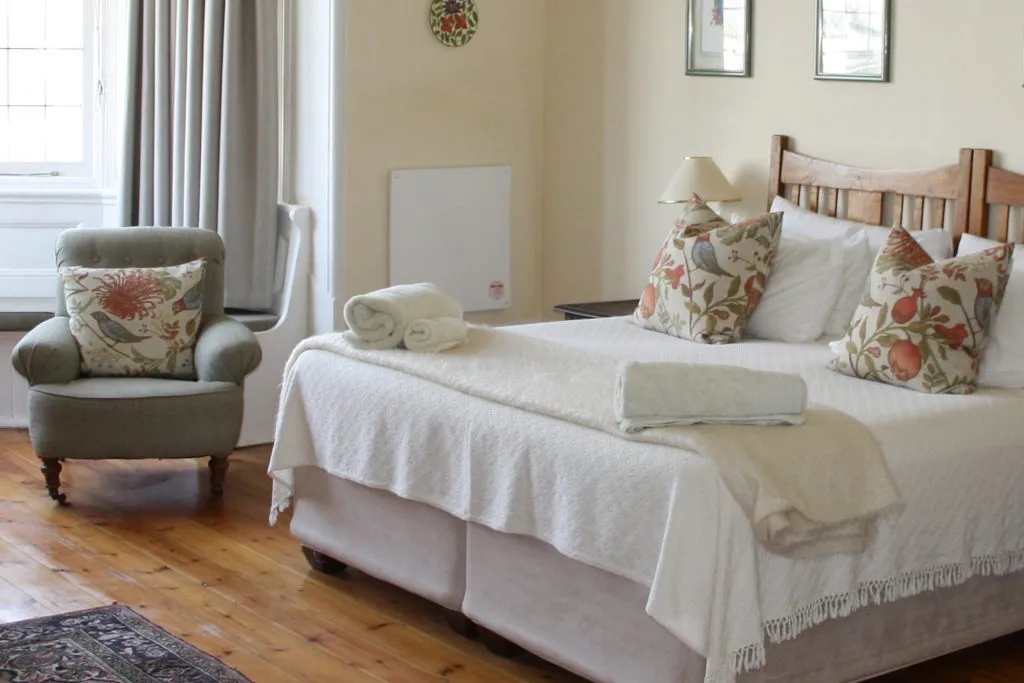 Cozy bedroom with a large bed armchair and floral pillows