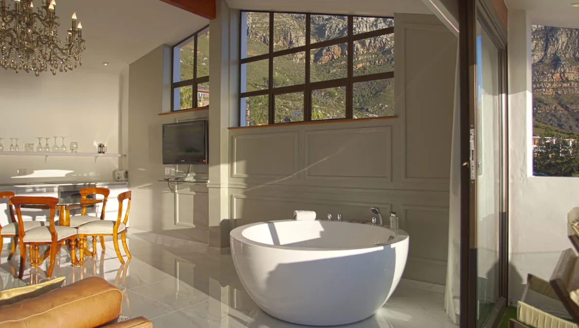 Modern bathroom with freestanding tub adjacent dining area and large windows