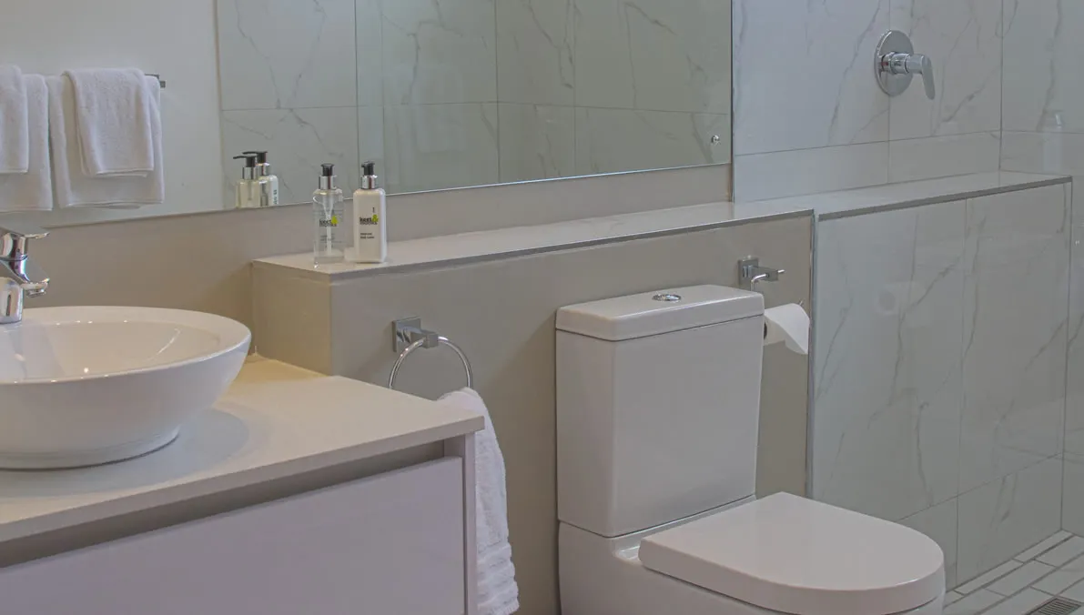Modern bathroom with sink toilet and large mirror