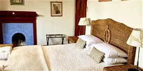 Cozy bedroom with a large bed blue fireplace and wicker headboard