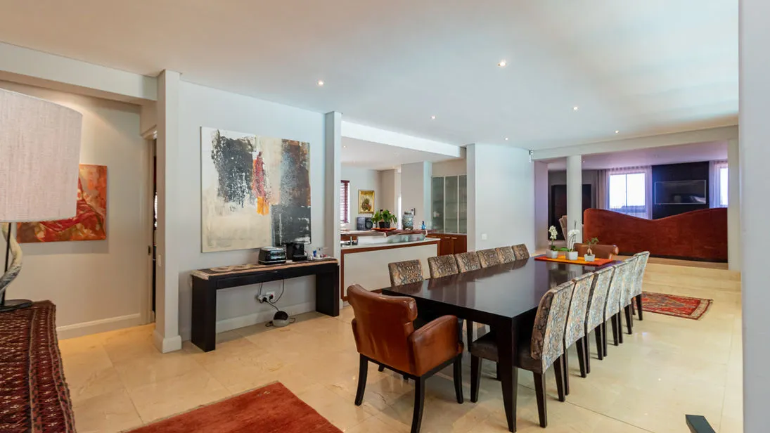 Modern dining room with large table chairs and abstract artwork on walls