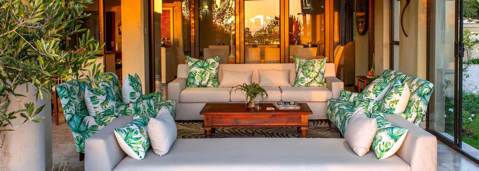 Outdoor seating area with white furniture and green leafpatterned cushions