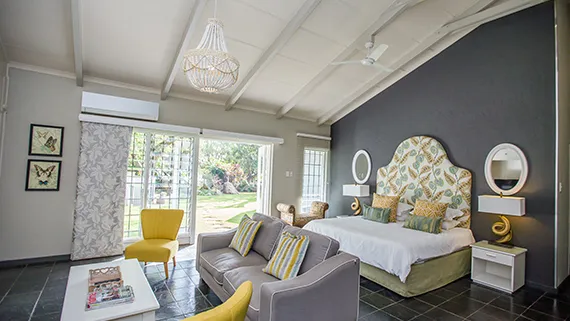 Bright bedroom with garden view yellow and grey furniture and butterfly decor