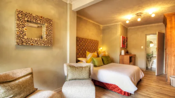 Cozy bedroom with a bed mirror and wooden furniture warm lighting