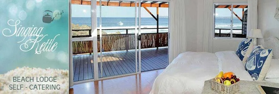 Beach lodge bedroom with ocean view bed and fruit basket on a table