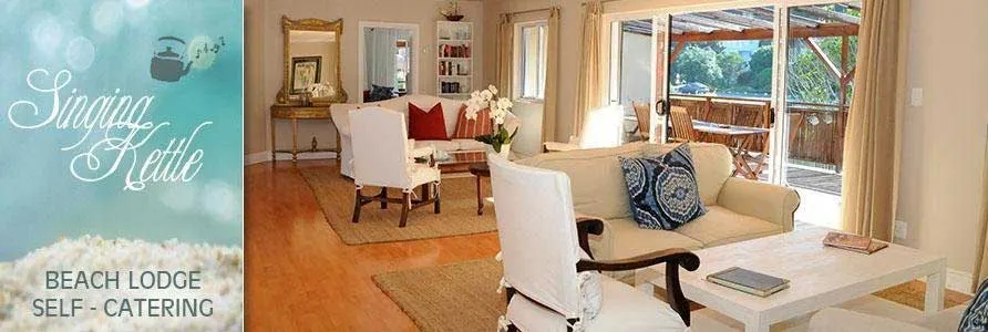 Cozy living room with white furniture and large windows overlooking a garden