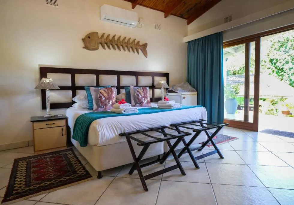 Bedroom with large bed wooden fish decor and sliding glass door to garden