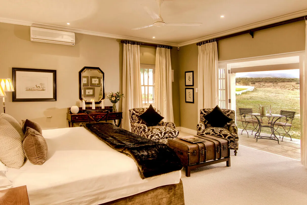 Cozy bedroom with open patio view two armchairs and a large bed