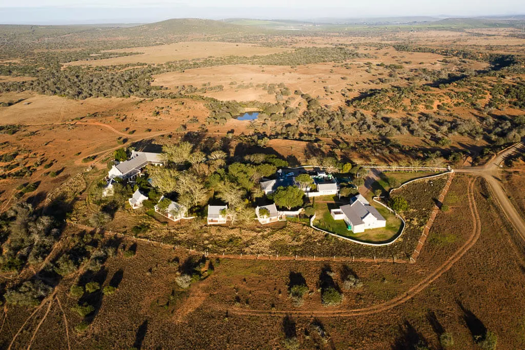 Aerial view of a small village surrounded by dry landscape and a pond