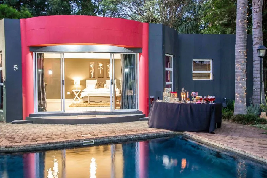 Modern house with pool outdoor table and lit bedroom view at night