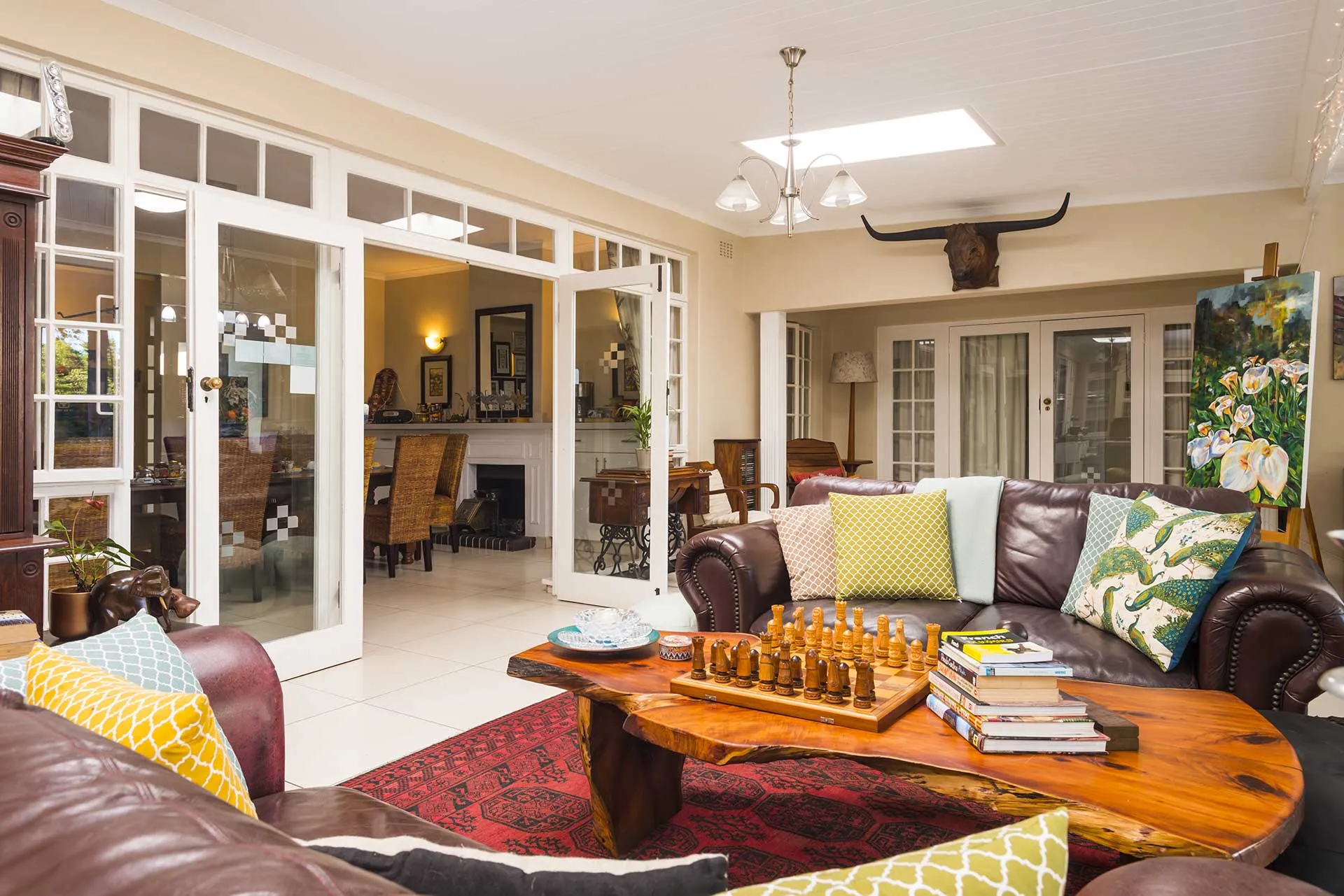 Cozy living room with wooden furniture colorful pillows and a chess set