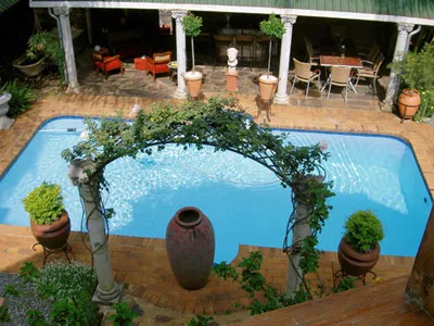 Swimming pool with surrounding patio plants and outdoor seating area
