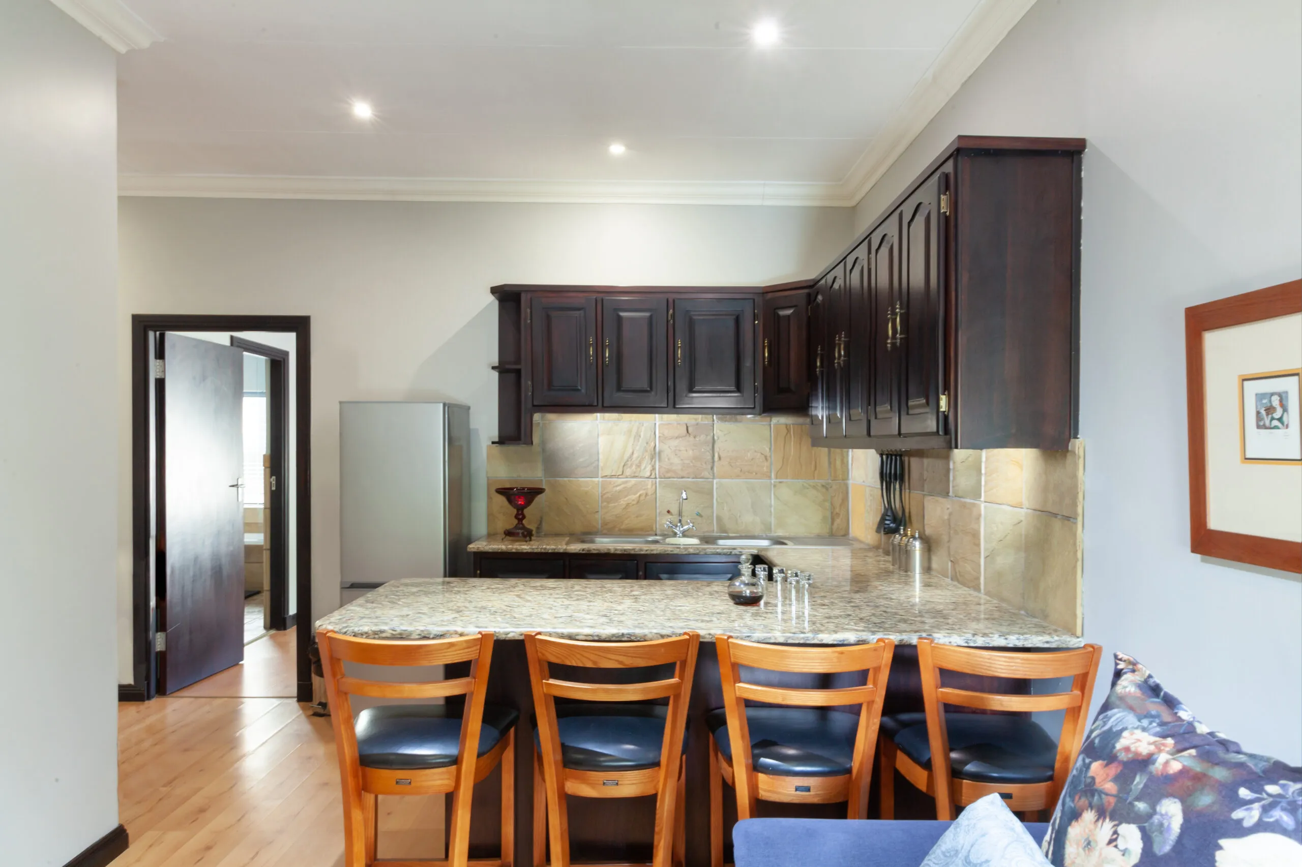 Modern kitchen with wooden cabinets granite counter and bar stools