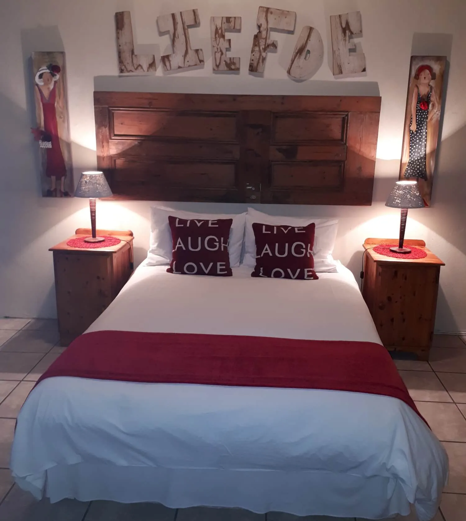 Bedroom with bed wooden headboard and wall art spelling LIEFDE