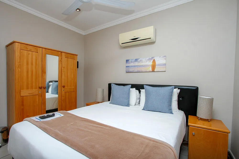 Bedroom with a bed wooden wardrobe nightstands and a ceiling fan