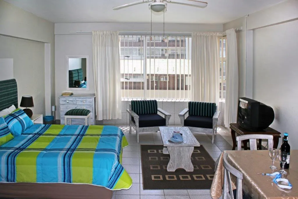 Bright studio apartment with bed seating area TV and dining table