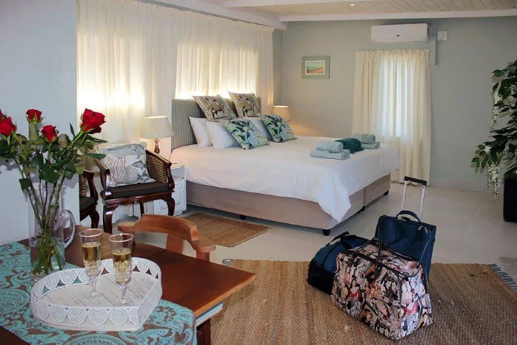 Cozy bedroom with luggage flowers and champagne on a table
