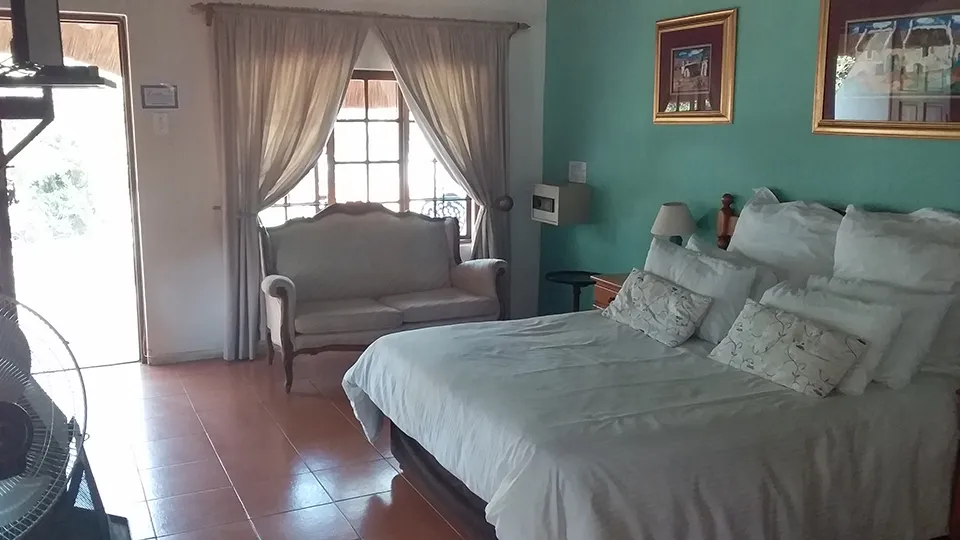 Bedroom with a large bed sofa and window with curtains