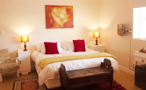 Cozy bedroom with a large bed wooden bench and warm lighting