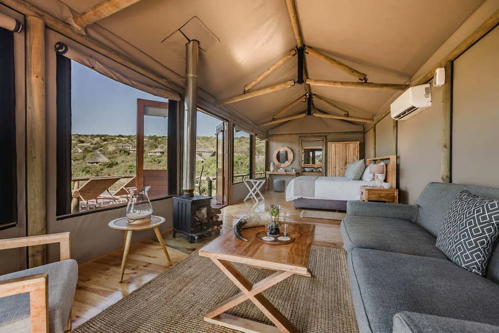 Cozy tent interior with sofa coffee table bed and scenic view outside