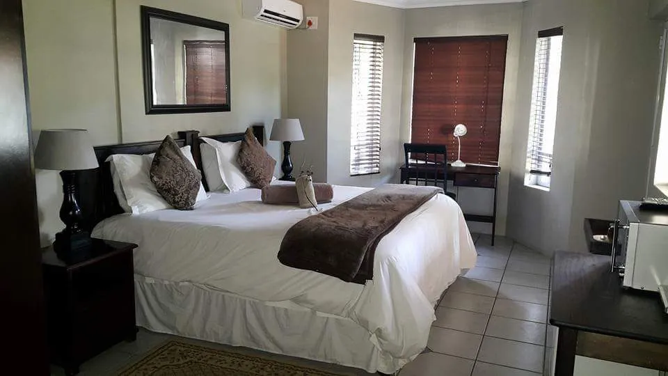 Modern bedroom with a large bed desk and window blinds