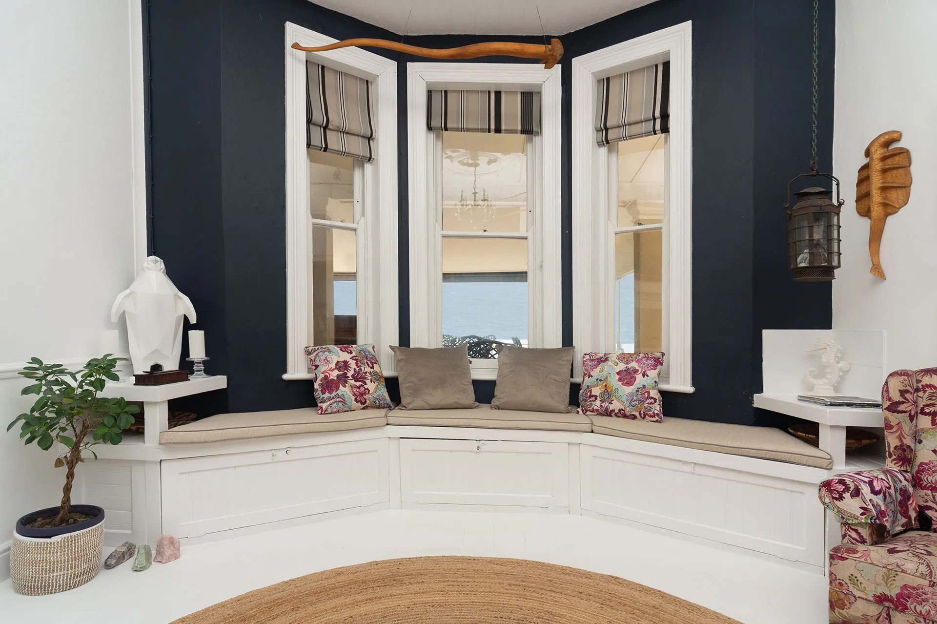 Cozy window seat with cushions and plants in a stylish modern room