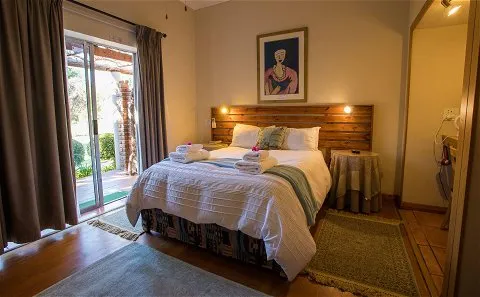 Cozy bedroom with a large bed wooden headboard and sliding glass door