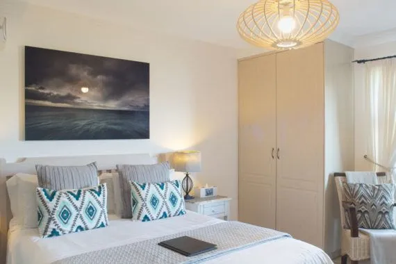 Cozy bedroom with a large bed pillows wardrobe and bedside lamp