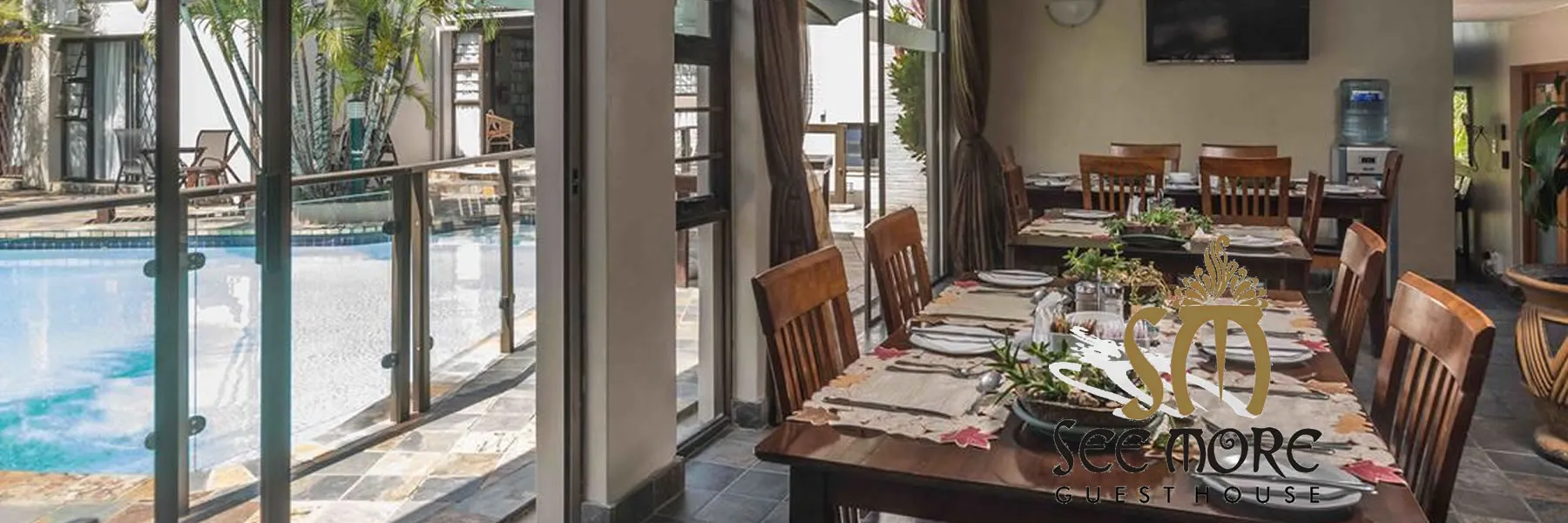 Dining area with wooden tables and chairs view of a swimming pool outside