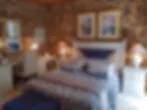 Blurred image of a bedroom with a bed nightstands and framed pictures