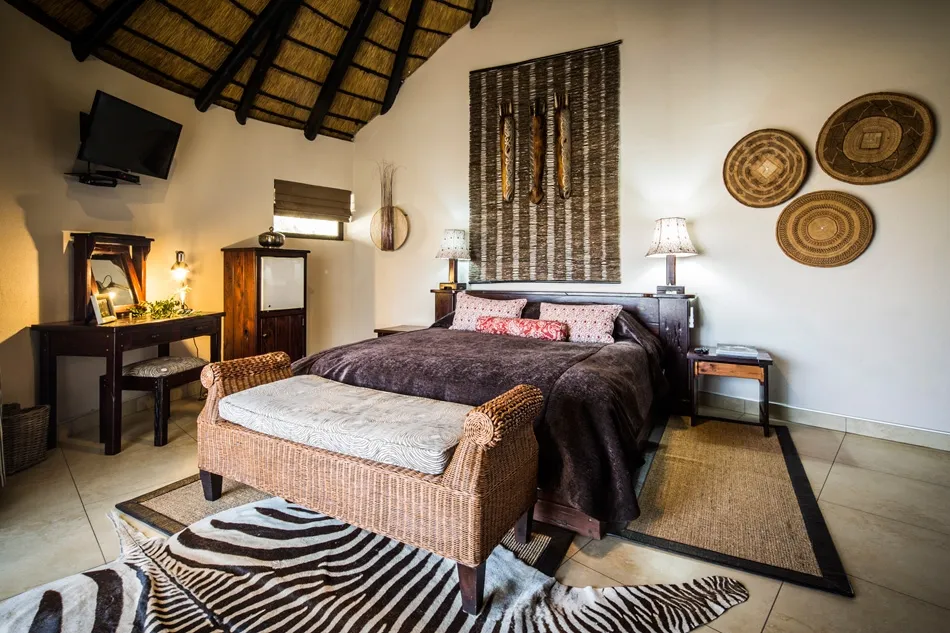 Cozy bedroom with a large bed wooden furniture and African decor elements