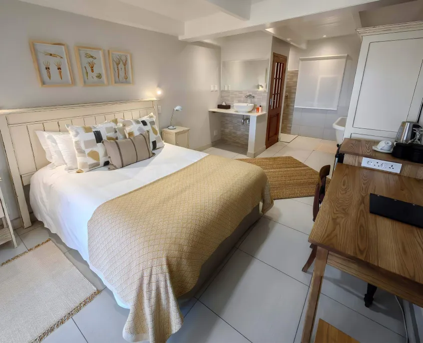 Cozy bedroom with a large bed desk and ensuite bathroom