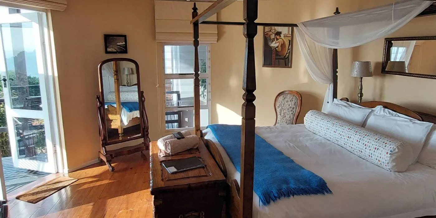 Bright bedroom with fourposter bed wooden furniture and large windows