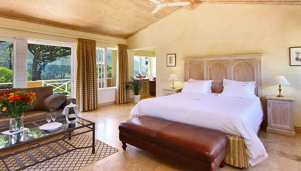 Bright bedroom with large bed sofa and scenic view through large windows