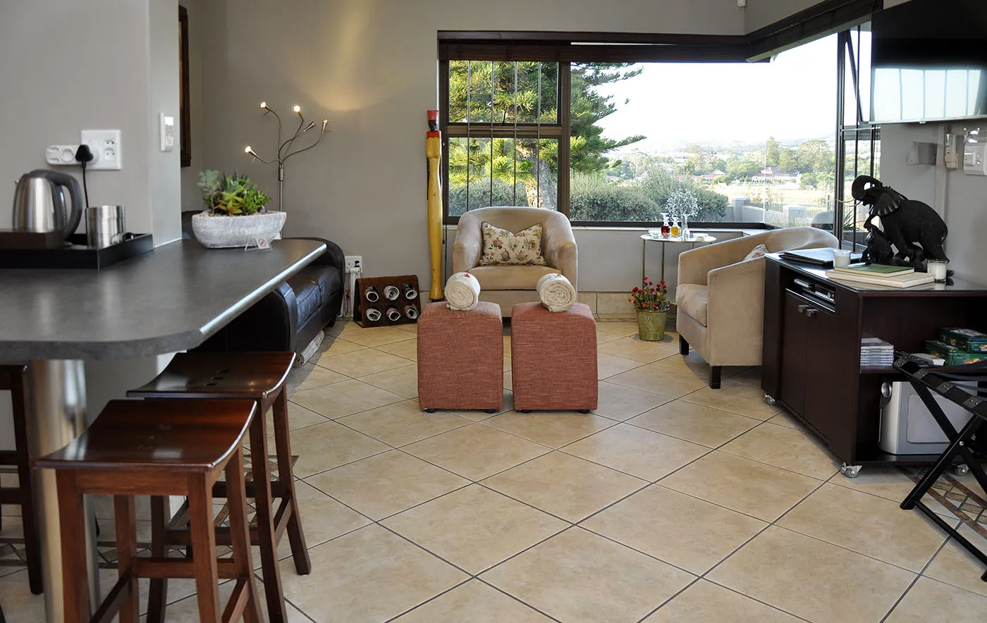 Modern living room with kitchen counter chairs and large windows