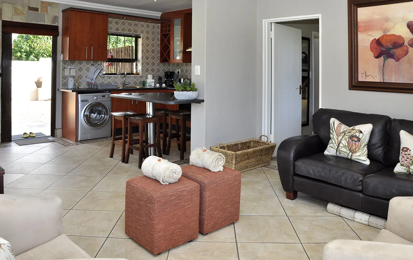 Openplan living area with kitchen seating and artwork featuring tiled floors