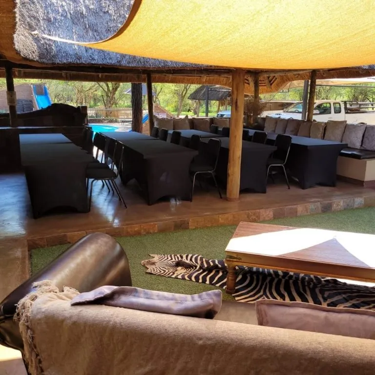 Outdoor seating area with tables chairs and a thatched roof