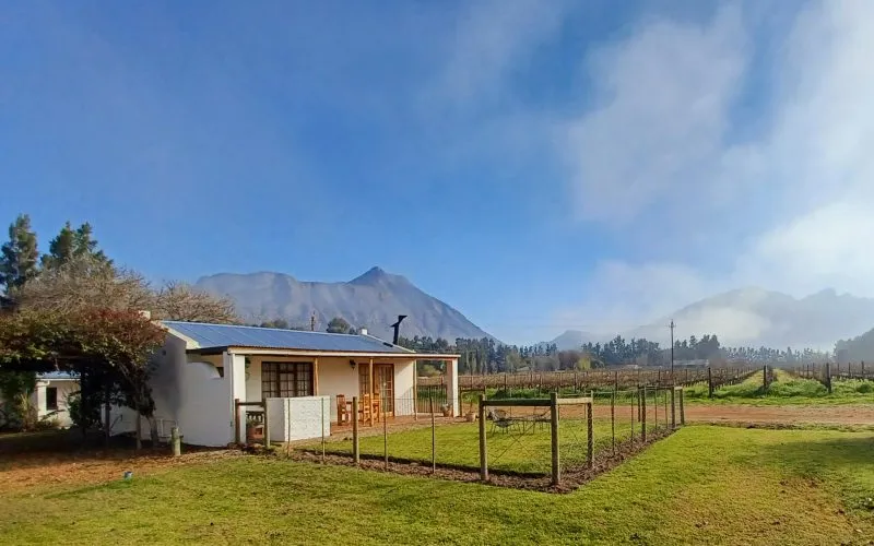 White house with mountains in the background and green fields