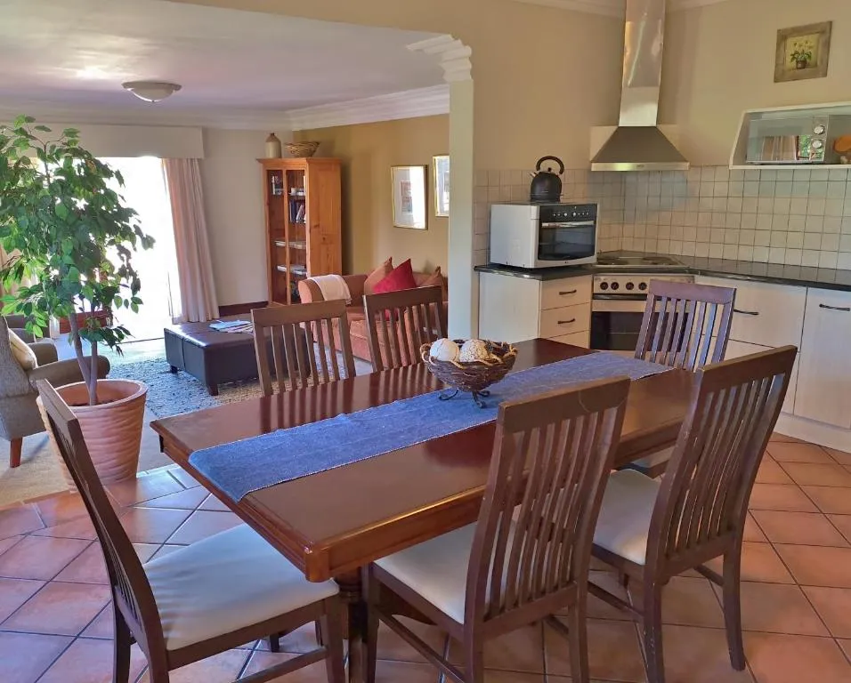 Wooden dining table with chairs in a cozy kitchen and living area