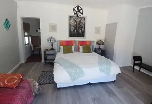 Bedroom with large bed wooden floor and modern decor