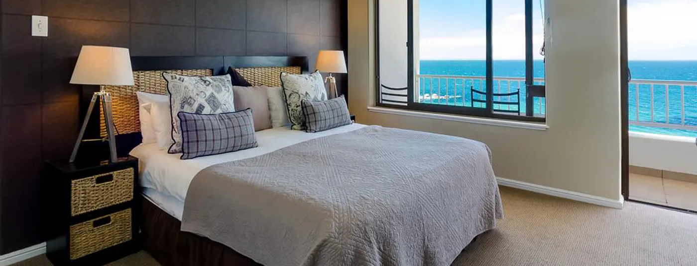 Bedroom with a large bed and ocean view through a large window