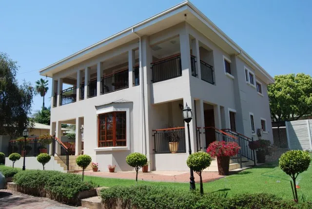 Modern twostory house with a wellmaintained garden and potted plants